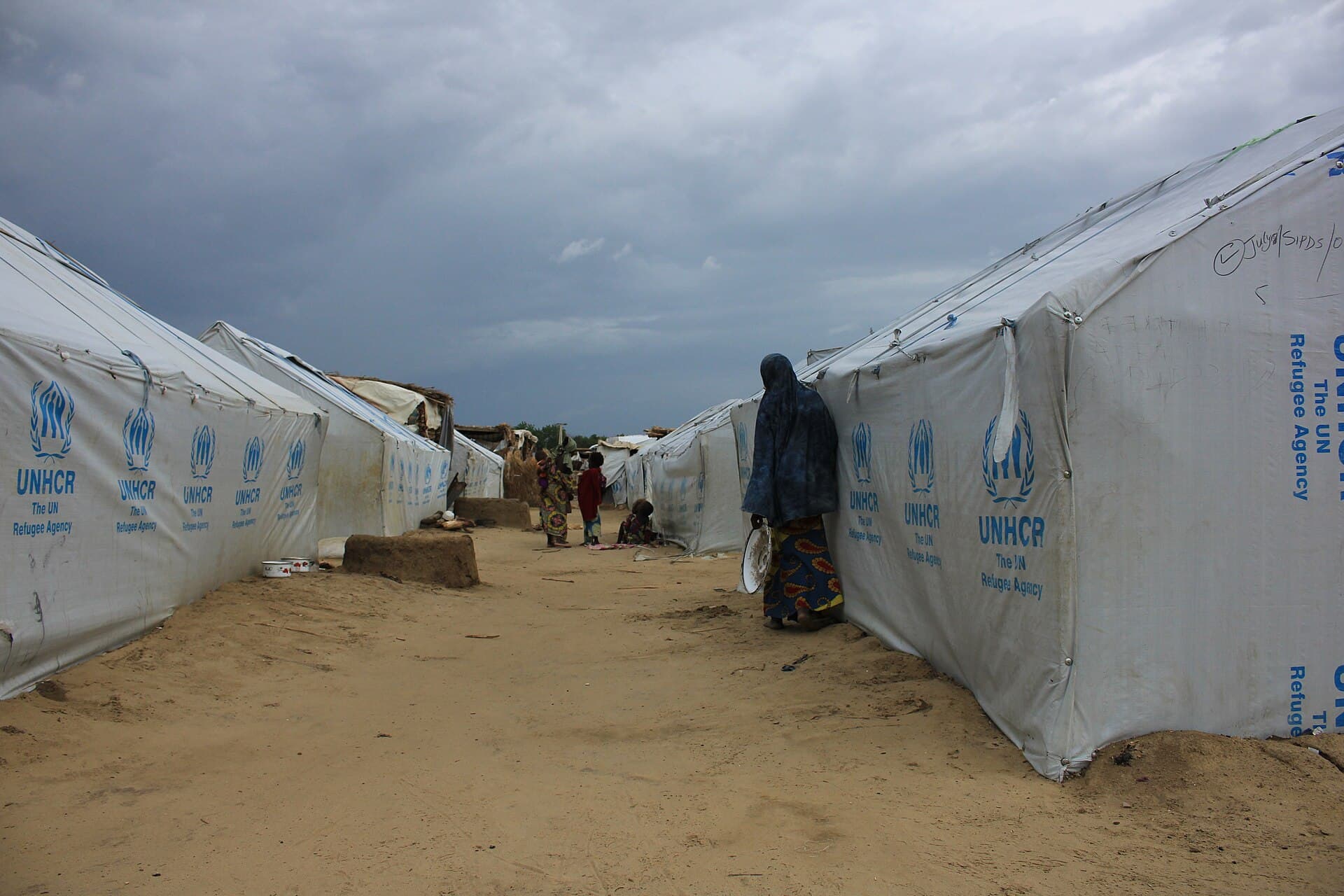 A woman and children among UNHCR shelters at a camp for displaced people in Maiduguri, Borno State